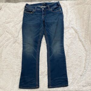 Silver Jeans Co. Suki Mid Rise Curvy Fit Bootcut jeans in a mid wash.